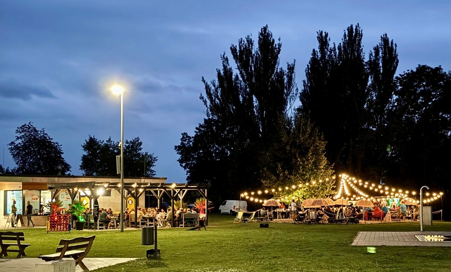 Beleuchtete Zelte mit Menschen am Abend im Schwimmbad